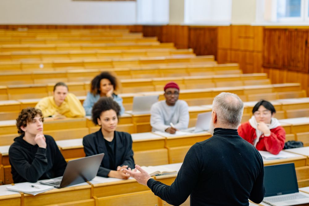 Profesor y estudiantes en una clase universitaria